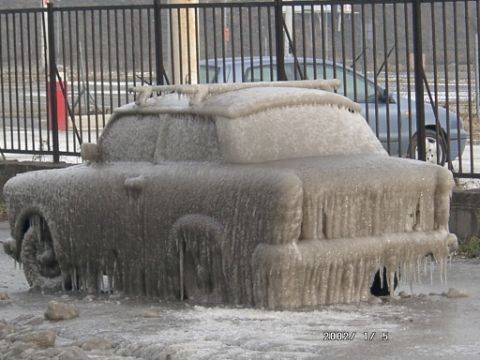 2003 Jeep TJ - A vehicle is completely encased in ice, with icicles hanging from its frame, on a cold winter day.