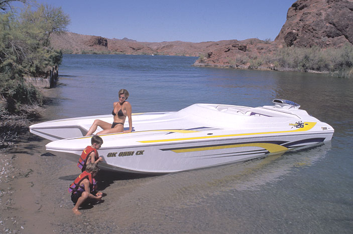 White and yellow speed boat with people on beach