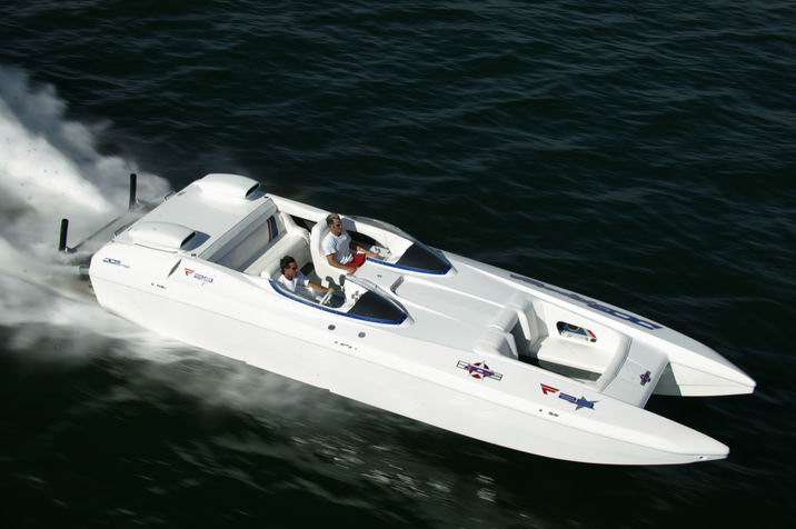 White performance boat with two people onboard speeding through dark water