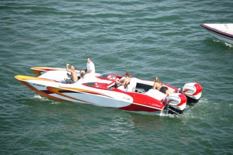 1991 Ford Bronco - Two speedboats navigate the water, one dual outboard motors and passengers enjoying the ride.