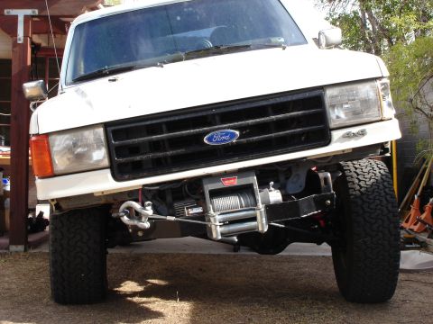 1987 Ford Bronco - Front view of a white 1987 Ford Bronco, equipped with a winch and a 4x4 badge.