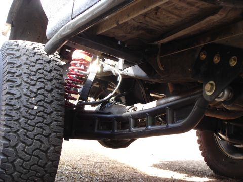 1987 Ford Bronco - Custom suspension components visible on an off-road vehicle's undercarriage.