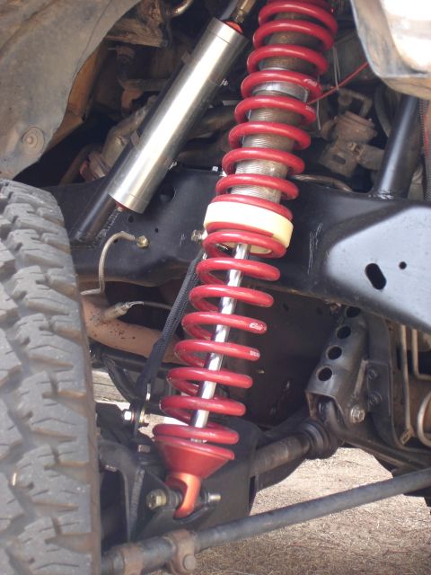 1987 Ford Bronco - Custom suspension parts are visible on this off-road vehicle, including a red coilover and a silver shock absorber.
