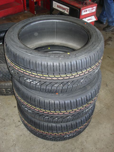 2003 Ford F-150 - A stack of four new tires is shown, with some sidewall text visible on each.