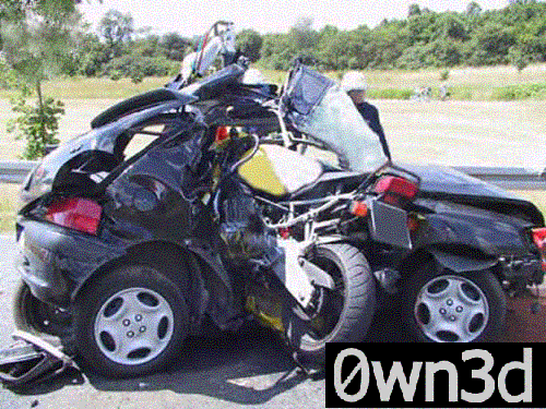 Dark small car torn apart in a severe crash beside a guardrail, roof cut away