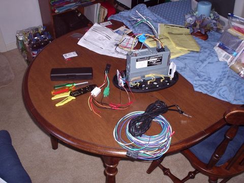 1998 Ford Taurus - Tools and components are spread across a table for a car stereo installation.