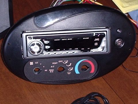 1998 Ford Taurus - A car's dashboard panel an aftermarket JVC radio and climate controls is shown, with wiring exposed.