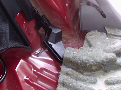 1998 Ford Taurus - Close-up view of the rear seatbelt anchor mechanism inside a vehicle.