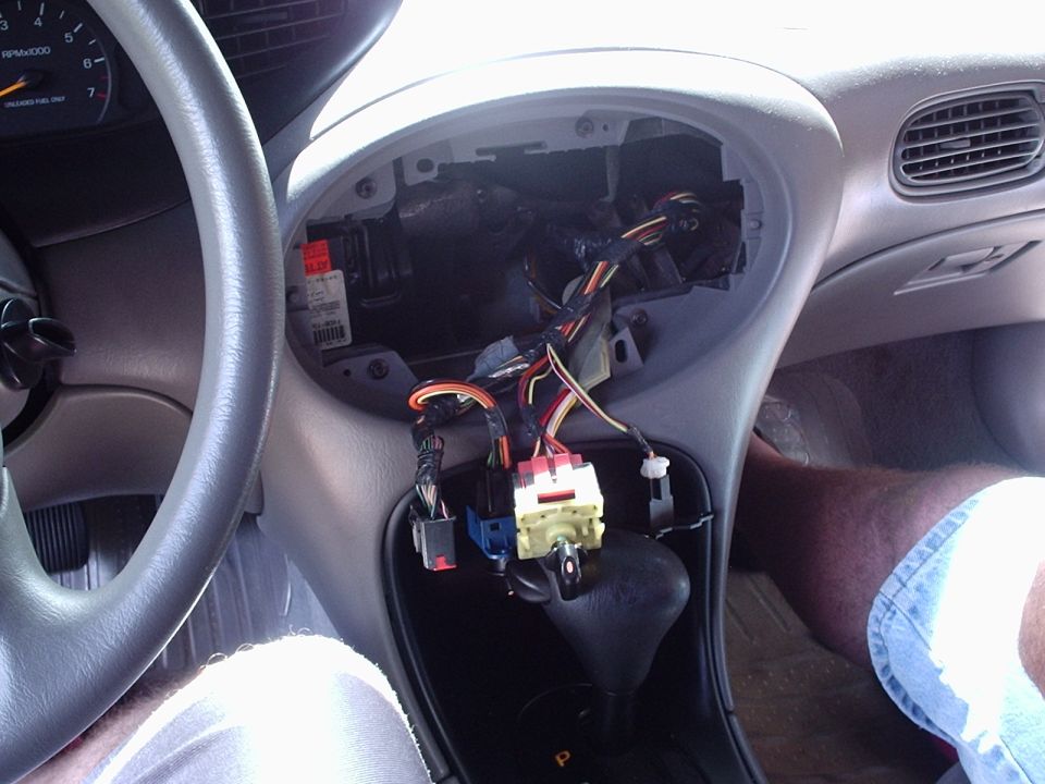 1998 Ford Taurus interior showing removed radio and exposed wiring harness