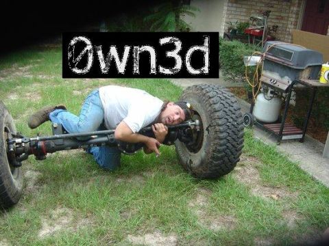 1985 Ford Bronco - A man lies on the grass beside a bare solid front axle assembly pulled out of the truck, complete with knuckles, hubs and one mounted mud-t…