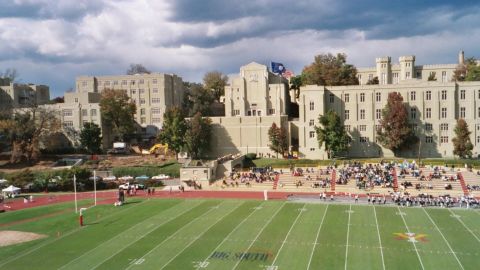1978 Ford Bronco - A football game is underway at a stadium with large buildings in the background.