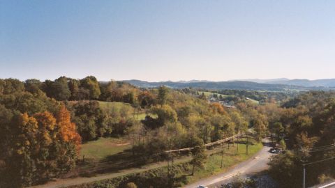 1978 Ford Bronco - A scenic view of a countryside road during the fall season, with a few vehicles present.