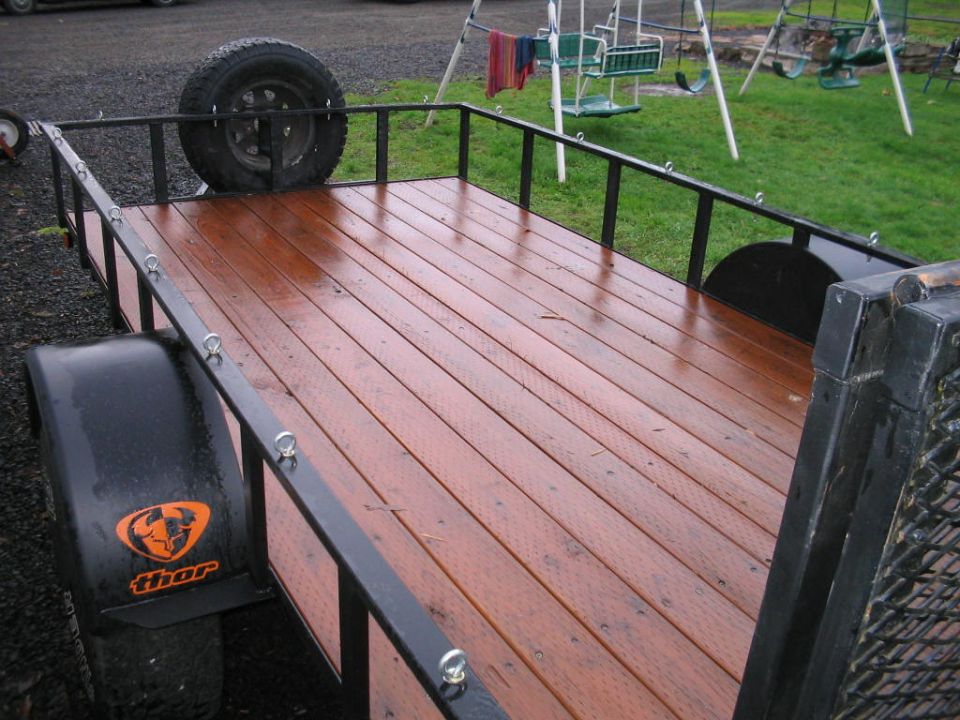 Trailer with wooden deck and spare tire mounted on the side