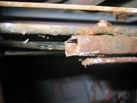 1995 Ford Bronco - Close-up view of a corroded metal bracket, likely from a vehicle's undercarriage.