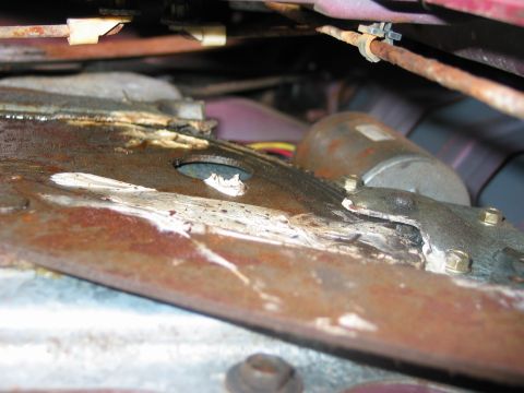 1995 Ford Bronco - Close-up view of a rusty window regulator mechanism, likely from a vehicle door.