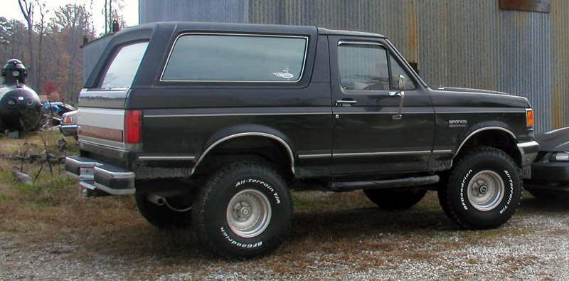 Black Ford Bronco parked outside a building. BFGoodrich All-Terrain T/A tires visible