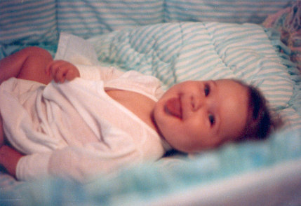 1991 Ford Bronco - A baby lies on a blanket, looking at the camera and sticking its tongue out.