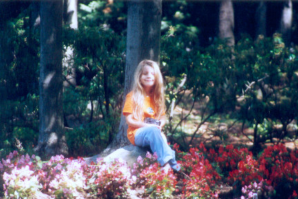 1991 Ford Bronco - A young girl sits in a garden surrounded by colorful flowers and trees.