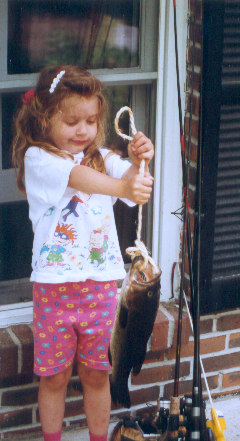 1991 Ford Bronco - A young girl proudly displays a fish she has caught, with fishing rods standing ready for more action.