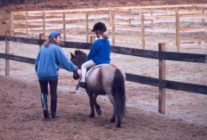 1991 Ford Bronco - A young girl receives riding instruction on a pony in an outdoor arena.