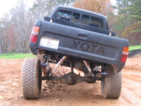 1986 Ford F-150 - This lifted Toyota pickup truck is shown from the rear, with its suspension and large tires prominent.