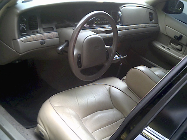 Tan leather interior of a 1999 Ford Crown Victoria, showing dashboard and seats