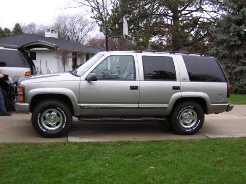 2000 Chevrolet Tahoe - Side view of a silver 2000 Chevrolet Tahoe SUV parked in front of a house.