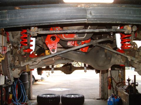 1994 Ford Bronco - The underside of a vehicle is shown, highlighting its suspension and drivetrain components.