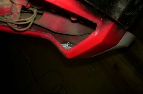 1981 Ford Bronco - A close-up view of a red fender well reveals wiring and some exposed metal components.