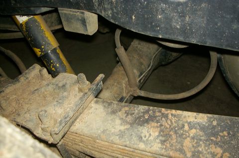 1981 Ford Bronco - The rear suspension of a 1981 Ford Bronco, a yellow shock absorber and leaf springs, is visible in this close-up shot.