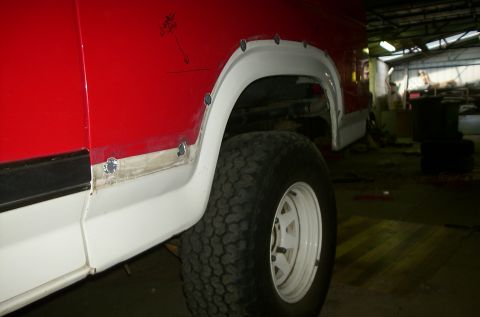 1981 Ford Bronco - The vehicle is in a workshop, undergoing body repair on the rear fender area.