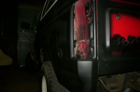 1981 Ford Bronco - The taillight housing is removed from this black SUV, revealing the red interior components within the cavity.