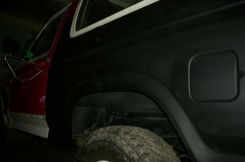 1981 Ford Bronco - The rear quarter panel of a 1981 Ford Bronco is shown with a red door and black paint.