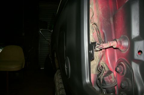 1981 Ford Bronco - Close-up view of the wiring harness and interior paint on the rear quarter panel of a vehicle.