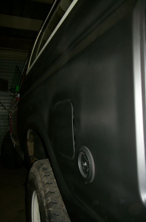 1981 Ford Bronco - Close-up of a vehicle's rear quarter panel, a fuel door and gas cap.