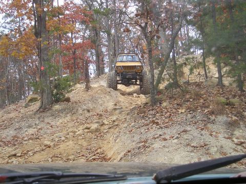 1996 Ford Bronco - Off-road vehicle navigating a challenging rocky incline during an autumn day.