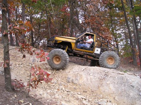 1996 Ford Bronco - Custom off-road vehicle navigates a challenging rocky terrain during an autumn day.