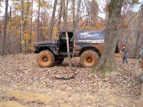 1996 Ford Bronco - This heavily modified 1978 Ford Bronco is shown off-road in a forest during autumn.
