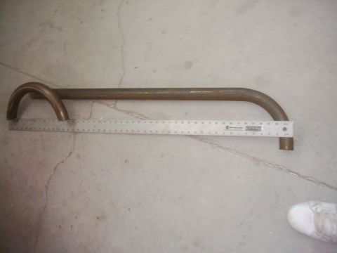 1978 Ford Bronco - A metal tube is measured with a ruler on a concrete floor.