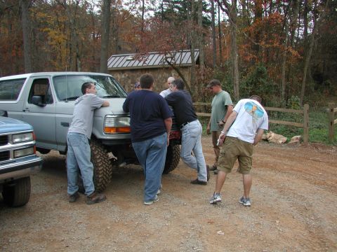 1985 Ford Bronco - A group of men are gathered around a lifted 1985 Ford Bronco in an outdoor setting.