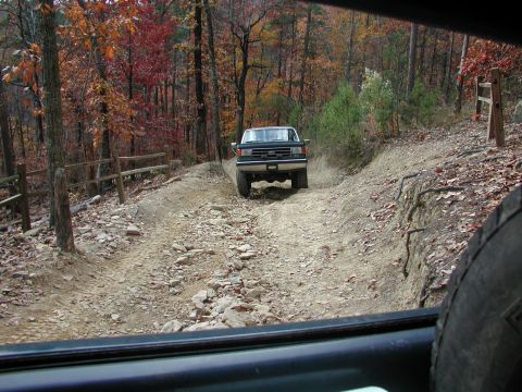 1985 Ford Bronco - Ford F-Series truck navigates a challenging rocky trail during autumn, with another vehicle in view.