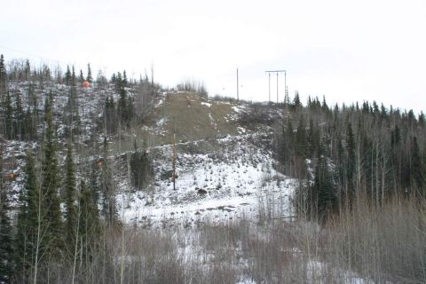 2003 Jeep TJ - Winter scene of a snow-covered hillside with trees and utility poles under a cloudy sky.