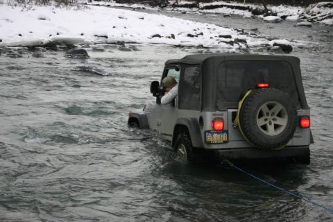 2003 Jeep TJ - 2003 Jeep TJ navigating a river with snow on the banks.