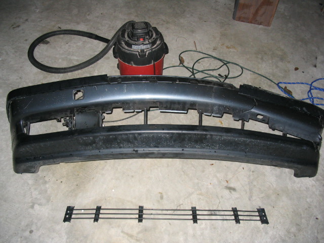 Dark gray bumper and grille assembly with a shop vac in background