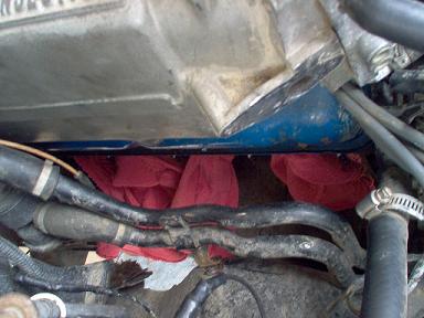 1988 Ford Bronco - Red rags are stuffed into an opening in the engine bay, likely to prevent debris from entering.