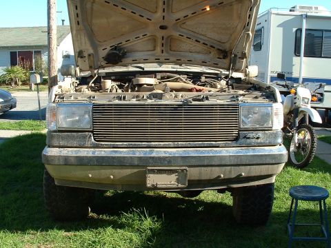 1990 Ford Bronco - The front of a 1990 Ford Bronco is shown with its hood open, revealing the engine compartment.