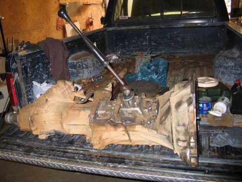 1989 Ford F-150 - Transmission and shifter assembly removed from a vehicle and resting in a truck bed.