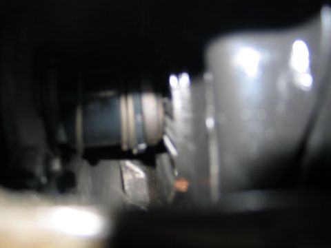 1989 Ford F-150 - A blurry view of a vehicle's driveshaft and U-joint, likely taken during a repair.
