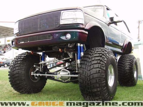 1994 Ford Bronco - This heavily modified Ford truck features an aftermarket grille and oversized tires, suggesting a model year around 1992-1996.