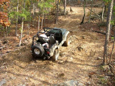 1995 Ford Bronco - A Jeep CJ-7 navigates a rocky, wooded trail during the fall.